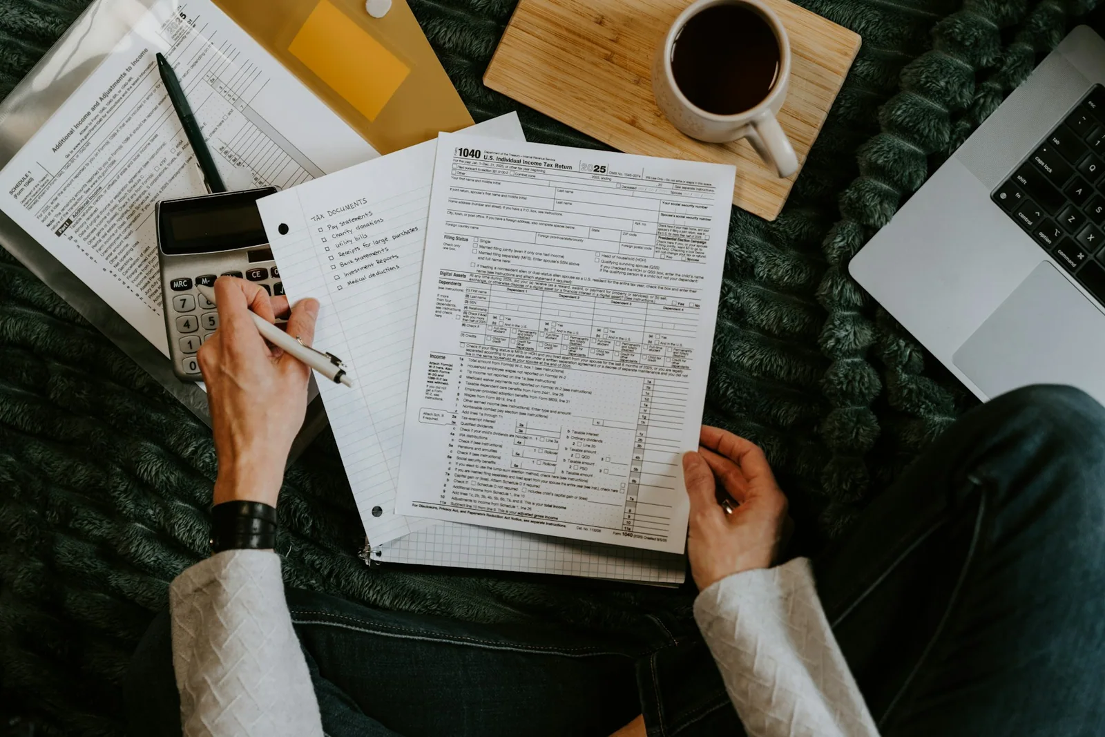 US tax forms, a calculator and a laptop on a desk