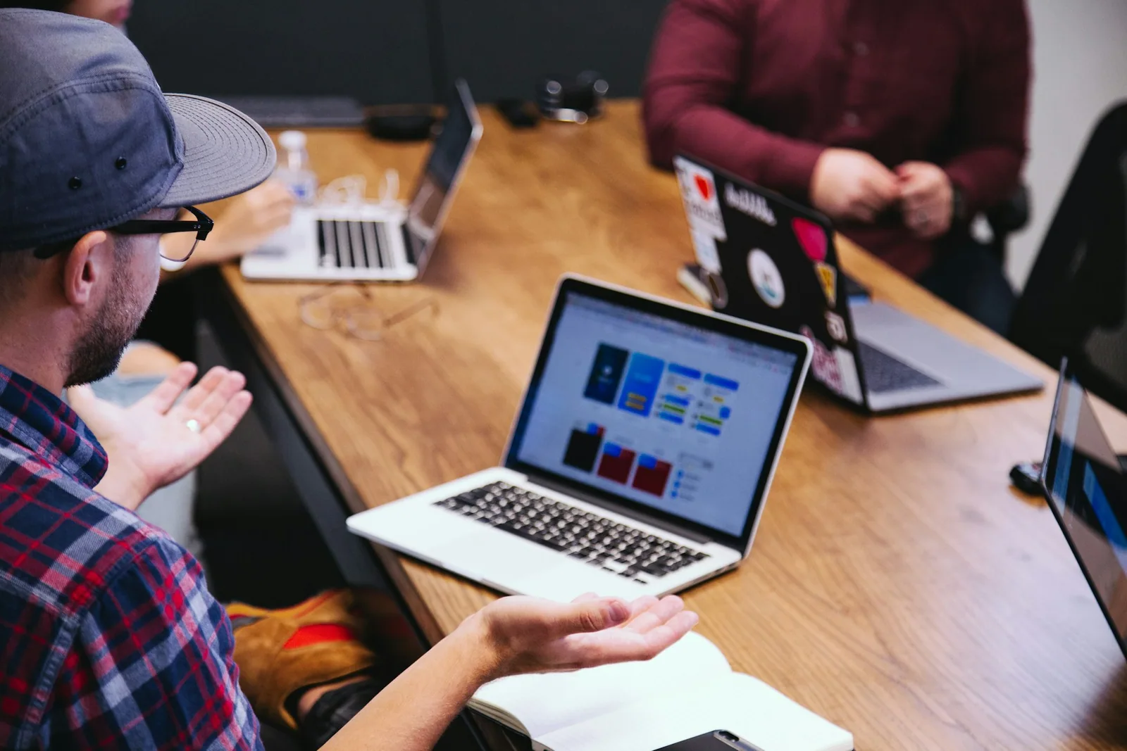 People discussing work around laptops at a meeting table